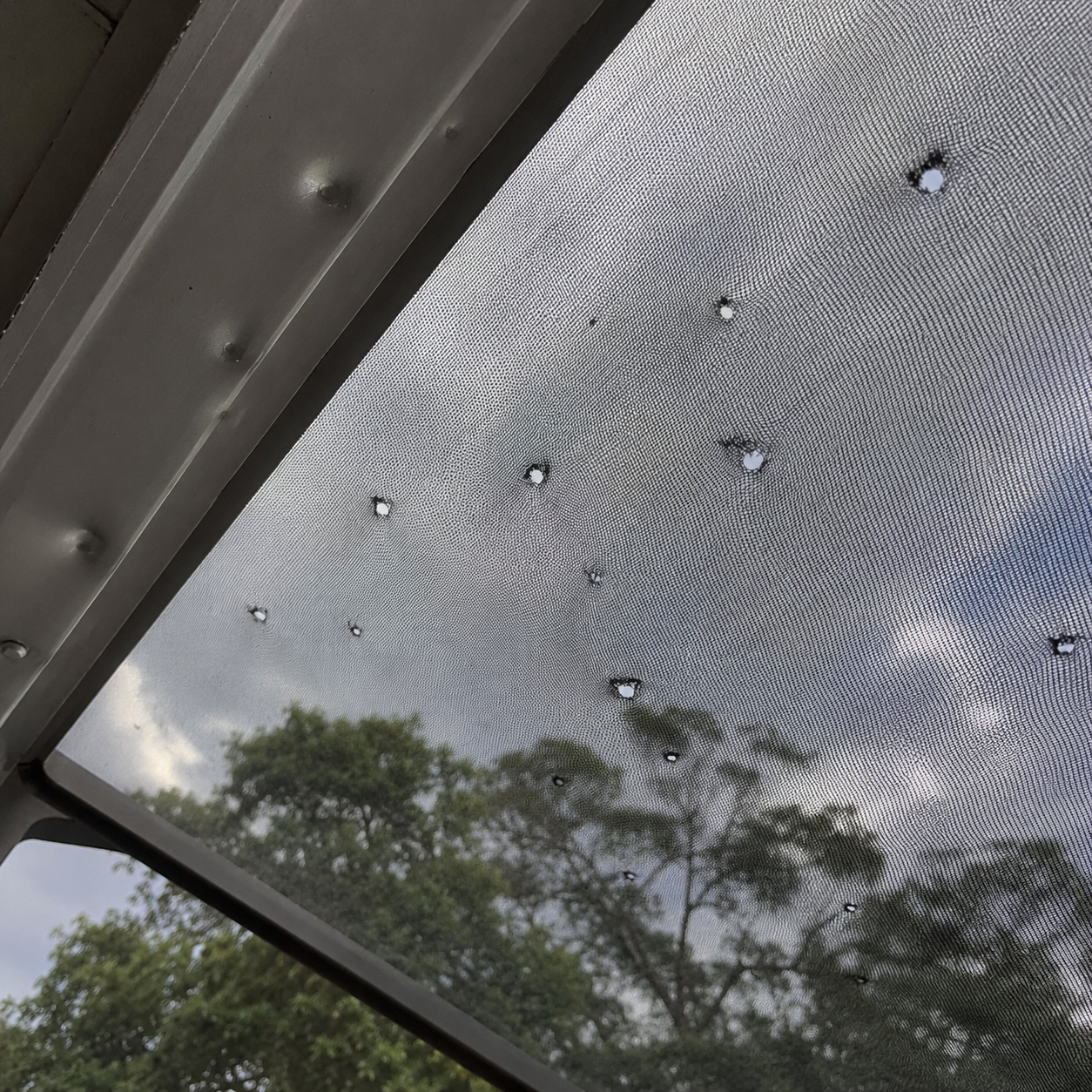 Lanai screen with hail damage puncture holes before repair